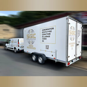 Marquage publicitaire complet sur un fourgon blanc et une remorque fermée pour l'entreprise SGE Événementiel, avec logos dorés, liste des services (Sonorisation, Éclairage, Vidéo) et QR Code.